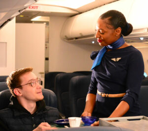 Hôtesse Mermoz dans un échange avec un passager dans un avion