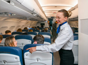Hôtesse en train d'installer et guider des passagers dans un avion lors d'un vol moyen courrier